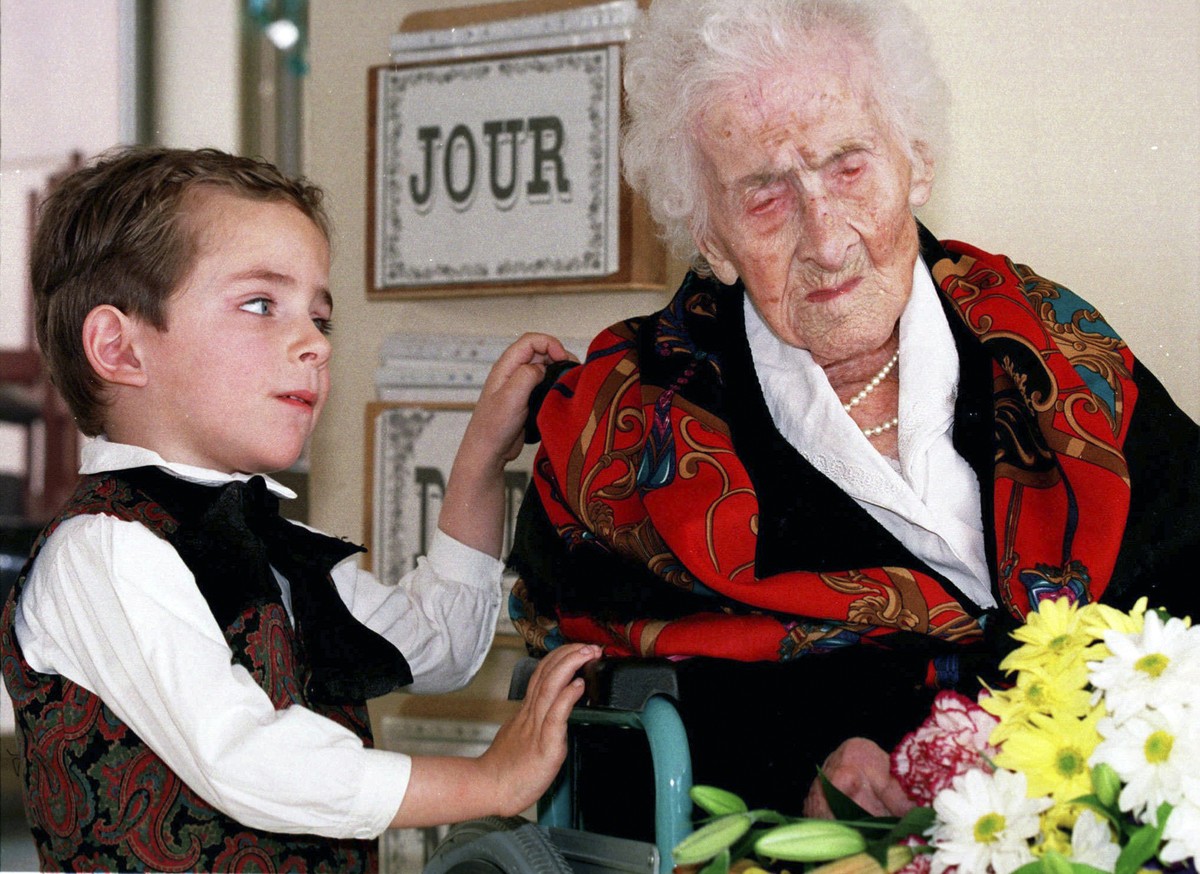 FILE - In this Feb. 12, 1997 file photo shows Thomas, 5, looks at Jeanne Calment after he brought her flowers at her retirement home in Arles, southern France. Calment, believed to be the world's ...