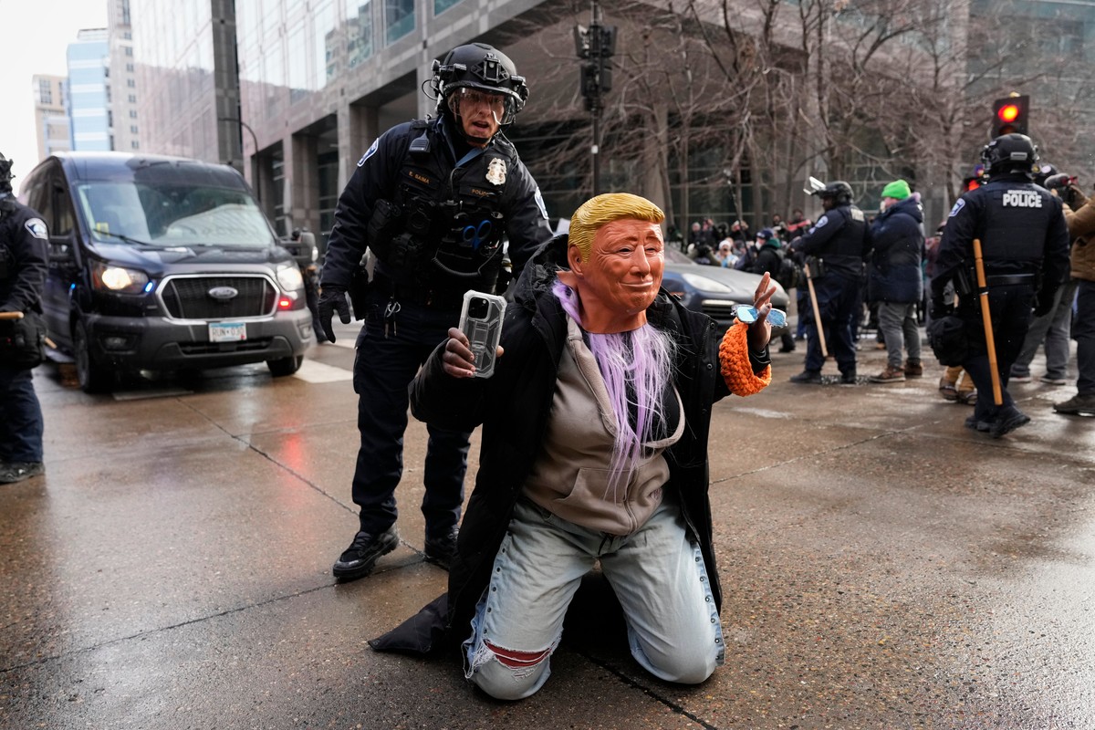 KEYPIX - A person wearing a Trump mask is told to get up by a Minneapolis Police officer Saturday, Jan. 17, 2026, in Minneapolis. (KEYSTONE/AP Photo/Yuki Iwamura)