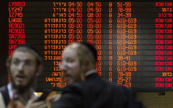 Ultra-Orthodox Jewish men stand in front of a departure time flight board displaying various cancellations in Hebrew at Ben Gurion International airport in Tel Aviv July 22, 2014. The Federal Aviation ...