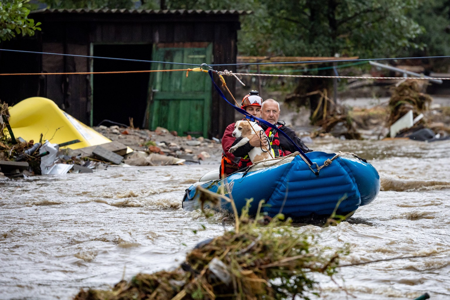 epa11606150 Firefighters help to evacuate a man with his dog from house in overfloating Bela river after heavy rain in town of Jesenik, Czech Republic, 15 September 2024. Floods caused by heavy rains  ...