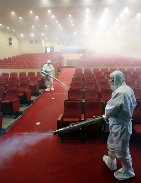 Zwei Männer desinfizieren einen Theatersaal in Seoul.