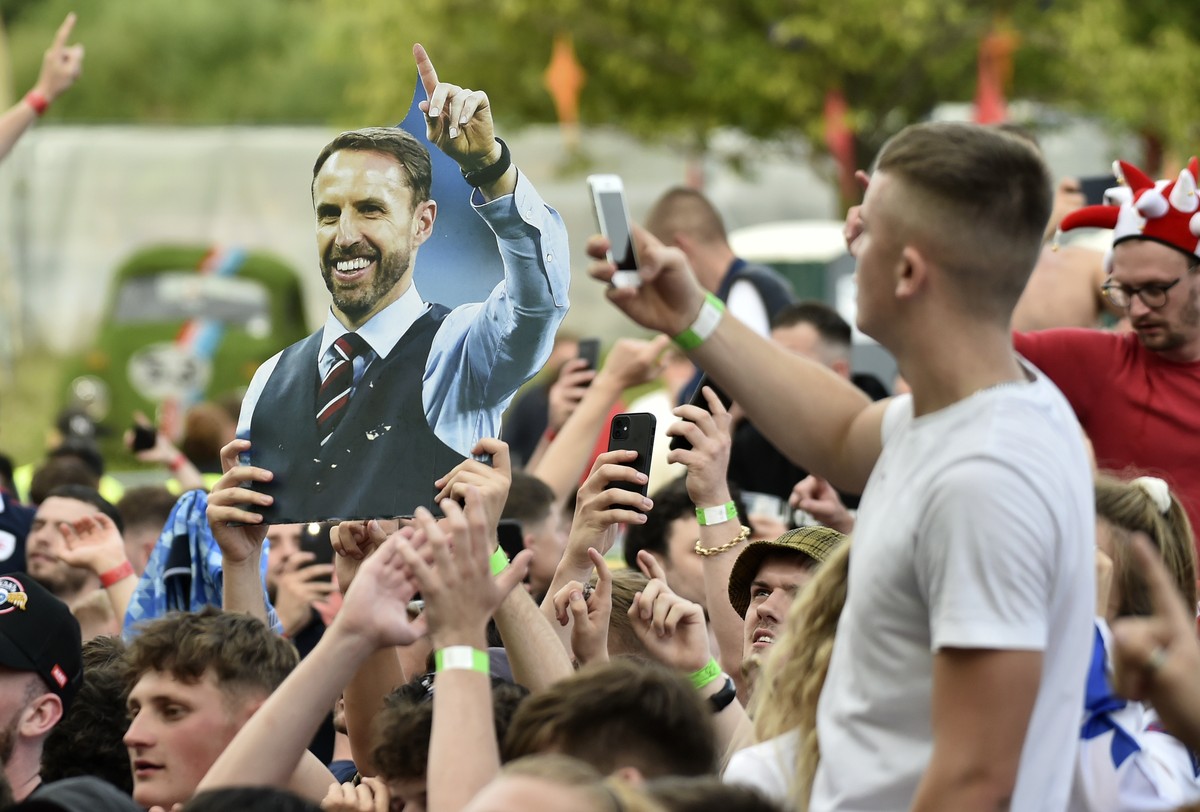 English supporters hold up a placard of England's manager Gareth Southgate as they celebrate at 4TheFans Fan Park, in Manchester, England, Tuesday, June 29, 2021 after winning the Euro 2020 round ...