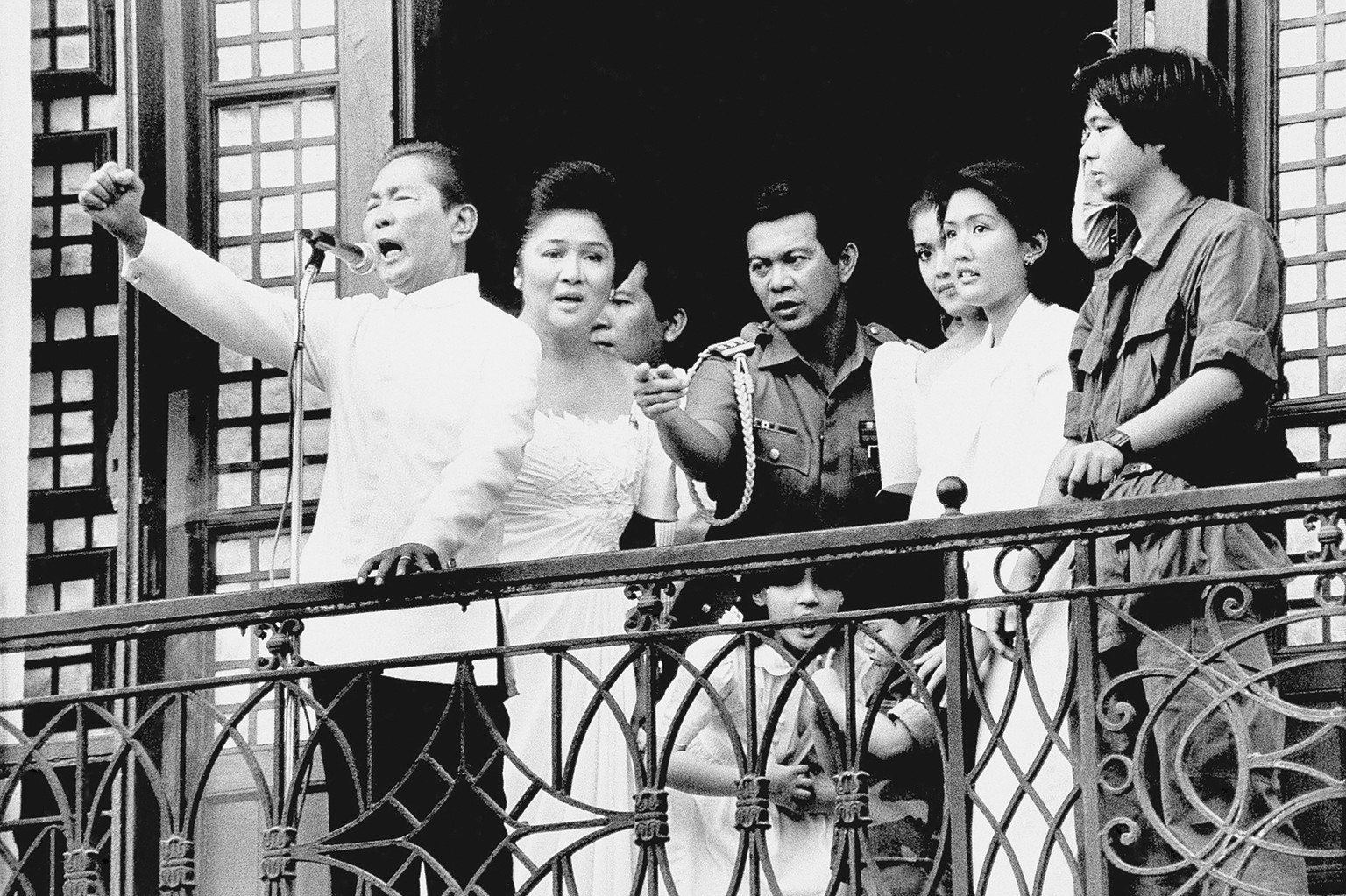 FILE - Ferdinand Marcos, with his wife Imelda at his side and Ferdinand Marcos Jr., far right, gestures strongly from the balcony of Malacanang Palace on Feb. 25, 1986 in Manila, just after taking the ...