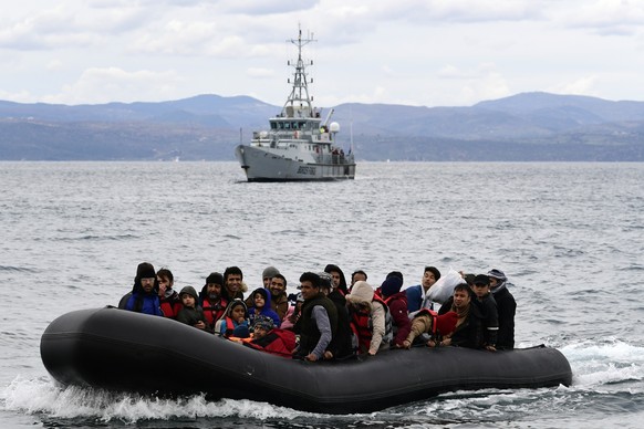 FILE - Migrants arrive in a dinghy with the Frontex ship in the village of Skala Sigaminias on the Greek island of Lesbos after crossing the Aegean Sea from Turkey on February 28, 2020.  Eur...