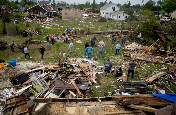 More than two dozen community members pull together to clean up the devastating aftermath at the home of Steve and Theresa Haskes in Gaylord, Mich., on Saturday, May 21, 2022, after an EF3 tornado rip ...