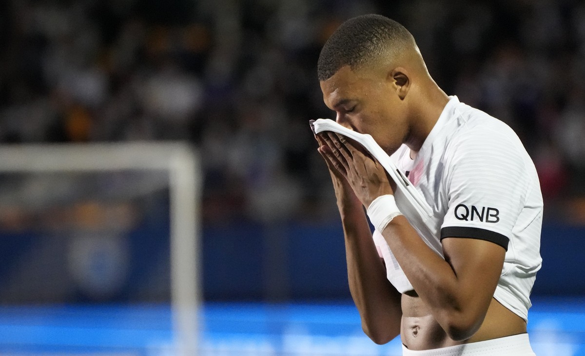 PSG's Kylian Mbappe wipes his face during the French League One soccer match between Troyes and Paris Saint Germain, at the Stade de l'Aube, in Troyes, France, Saturday, Aug. 7, 2021. (AP Ph ...