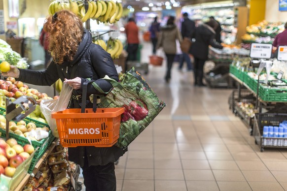 ZU DEN GESCHAEFTSZAHLEN 2013 DER MIGROS-INDUSTRIE STELLEN WIR IHNEN FOLGENDES THEMENBILD ZUR VERFUEGUNG - Eine Kundin mit einem Einkaufskorb nimmt eine Zitrone aus dem Regal, aufgenommen am 5. Maerz 2 ...