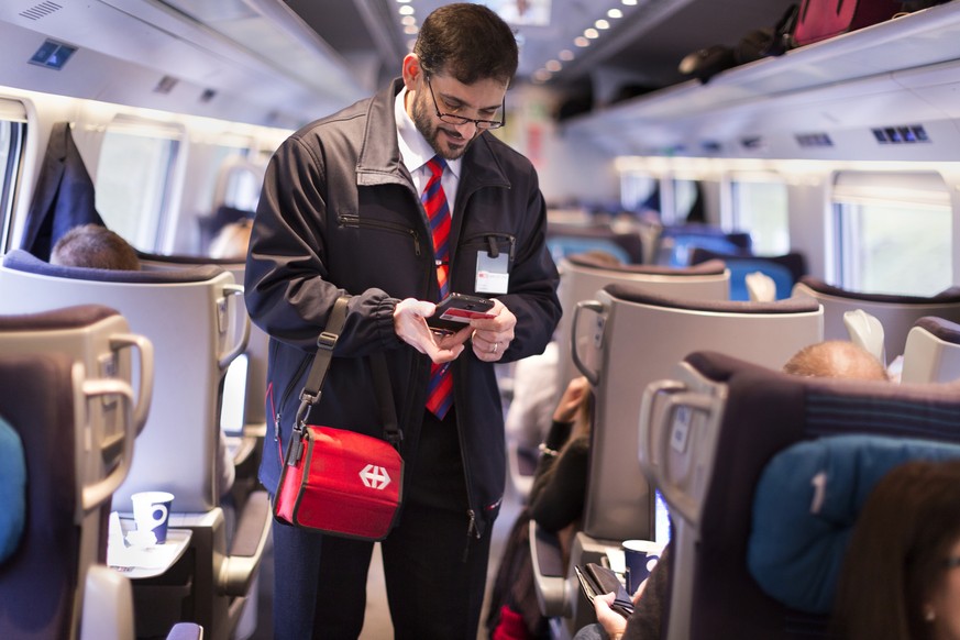 ZUR EINFUEHRUNG DES SWISSPASSES VOR DREI MONATEN STELLEN WIR IHNEN HEUTE, MITTWOCH, 4. NOVEMBER 2015, FOLGENDES NEUES BILDMATERIAL ZUR VERFUEGUNG --- Conductor Salvatore Grade verifies a train passeng ...