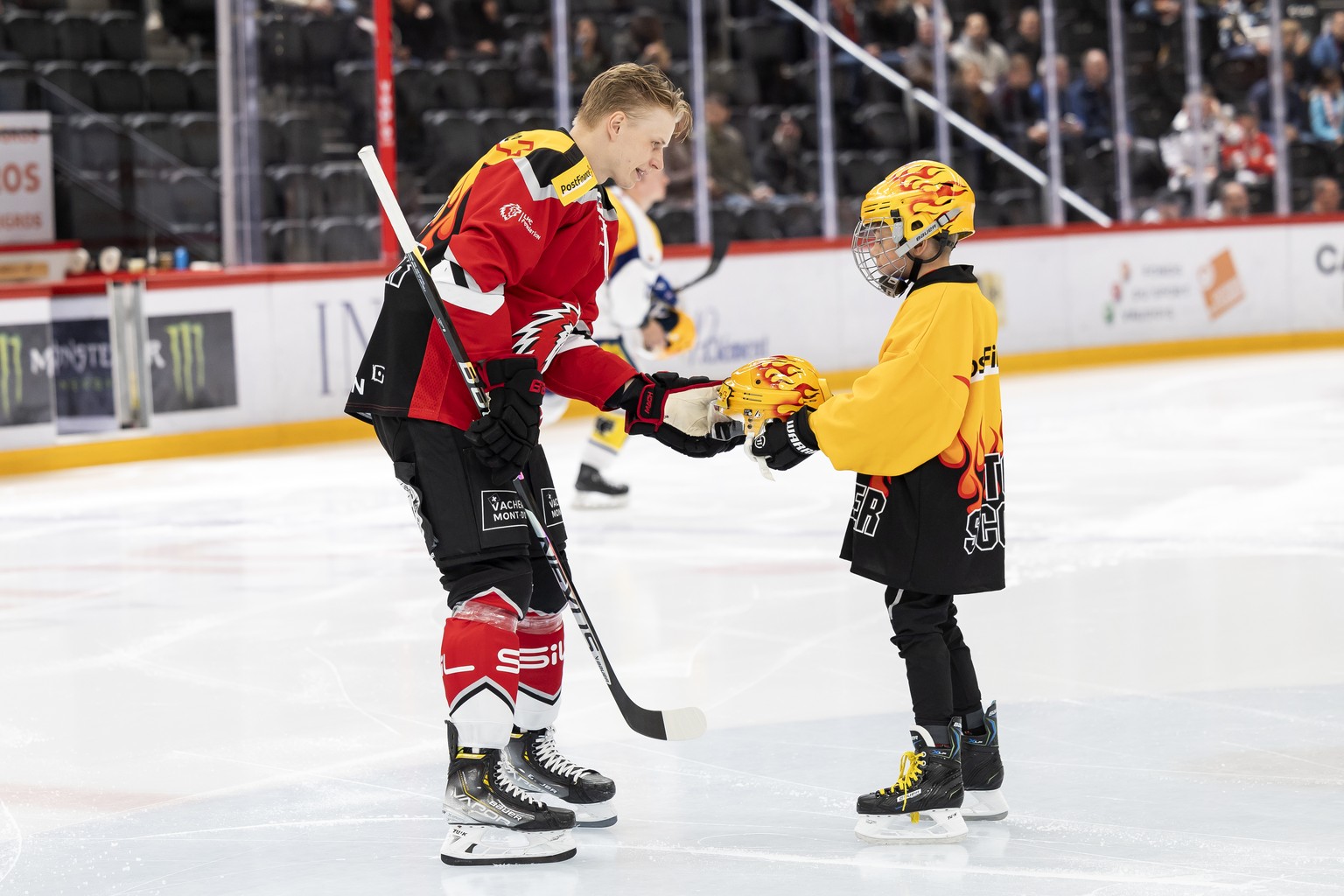 Le Top Scorer PostFinance lausannois Antti Suomela, gauche et le PostFinance&#039;s Kid, lors du match du championnat suisse de hockey sur glace de National League entre le Lausanne HC, LHC, et le EHC ...