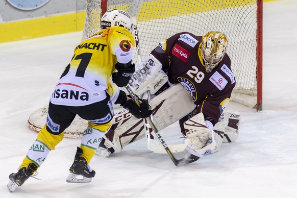 Le joueur bernois, Thomas Ruefenacht, gauche, a la lutte pour le puck avec le gardien genevois, Robert Mayer, droite, lors du 6eme match du quart de finale de play off du championnat suisse de hockey  ...