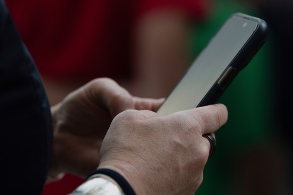 FILE - A person looks at their phone at Seattle?Tacoma International Airport on Sunday, June 1, 2025, in Seattle. (AP Photo/Jenny Kane, File)
iphone,phone,apps,applications,technology