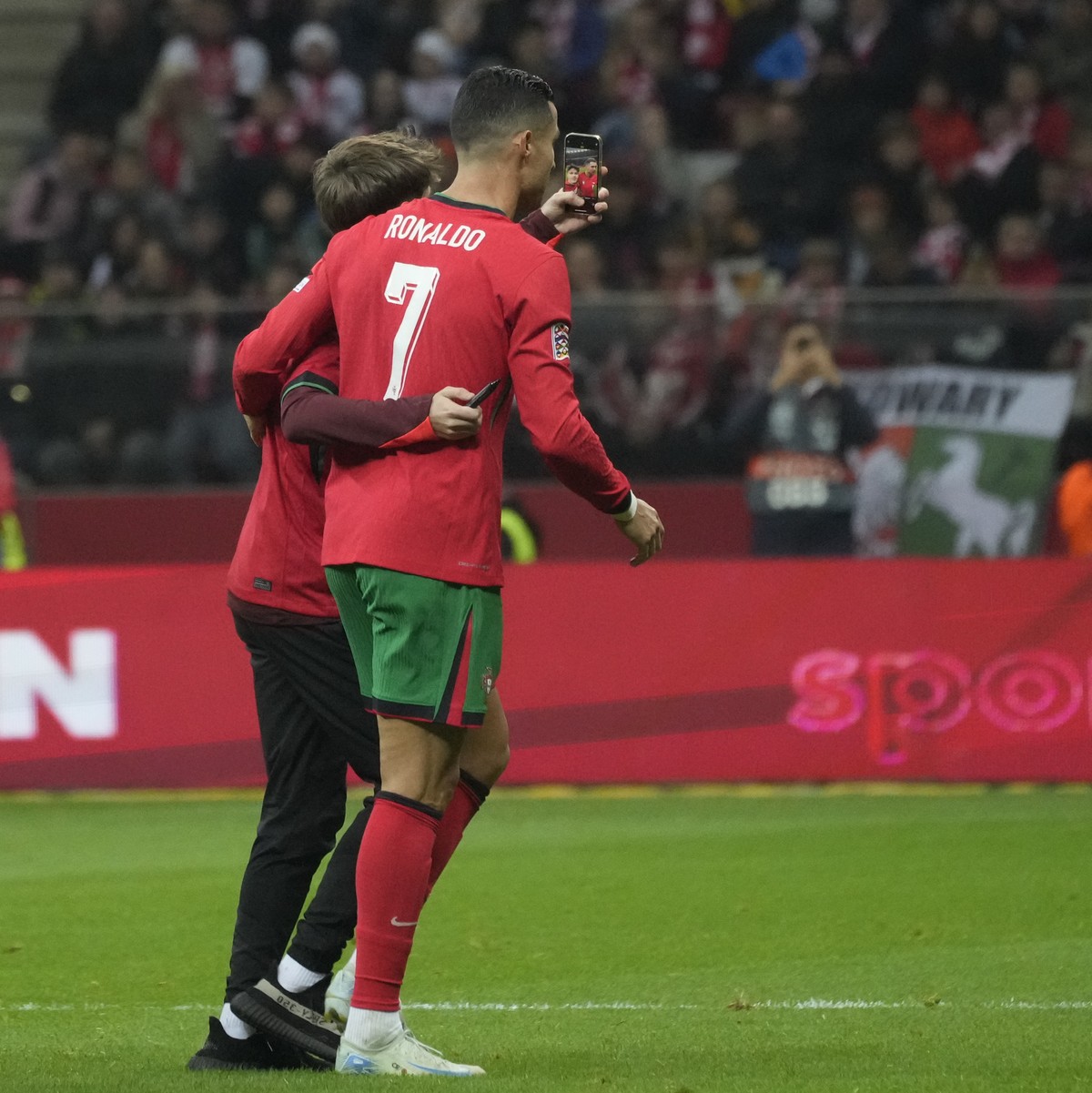 A pitch invader takes a selfie with Portugal's Cristiano Ronaldo as he left the pitch after being substituted during the UEFA Nations League soccer match between Poland and Portugal at Narodowy s ...