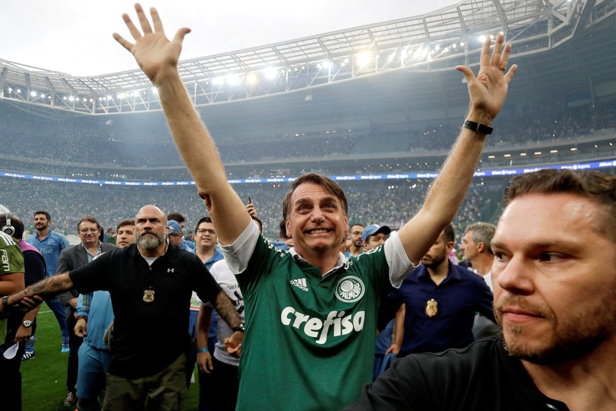 epa07204967 Brazilian President-elect Jair Bolsonaro (C) poses in a Palmeiras Club jersey, after the victory against Vitoria in the Brazilian Serie A soccer match between Palmeiras and Vitoria in Sao  ...