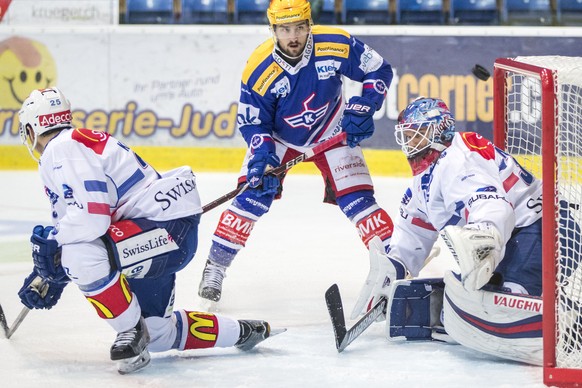 EHC Kloten Stuermer Vincent Praplan, Mitte, gegen ZSC Lions Torhueter Lukas Flueeler, rechts, und Roger Karrer, links, waehrend dem Eishockey-Meisterschaftsspiel der National League zwischen dem EHC K ...