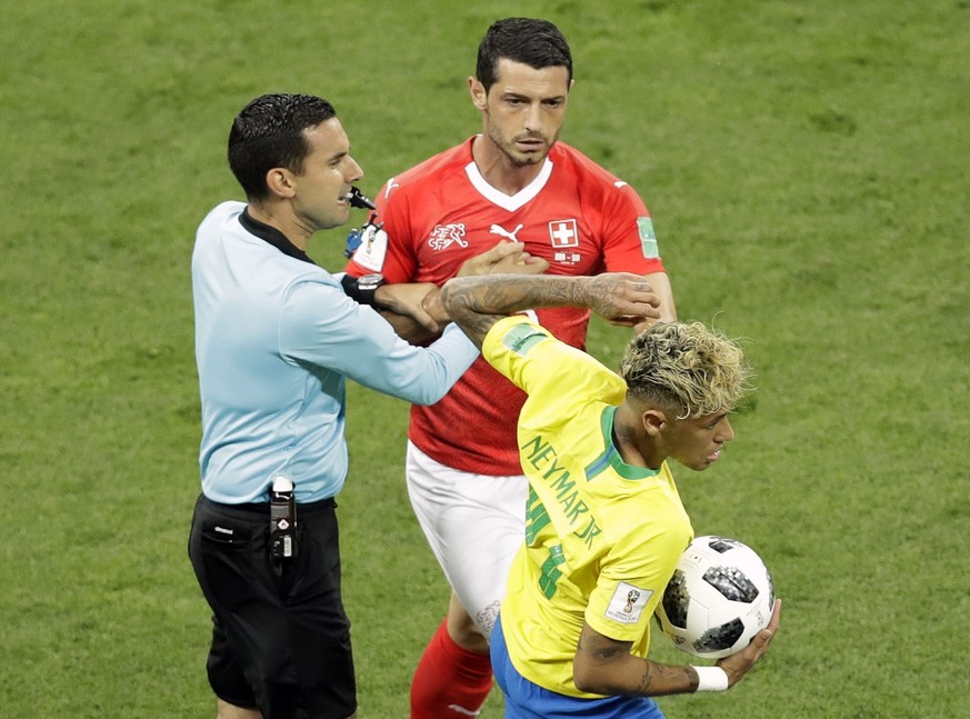 Mexican referee Cesar Arturo Ramos, left, tries to stop Switzerland's Blerim Dzemaili, center, as he tries to take the ball from Brazil's Neymar during the group E match between Brazil and S ...