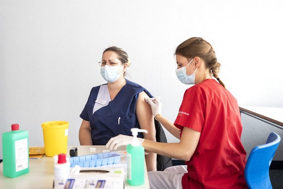 Pflegehelferin Sarmite Kisele, links, wird von Bettina Beerli, rechts, klinische Pflegespezialistin, gegen das Coronavirus geimpft, in einem Pflegezentrum in Embrach, aufgenommen am Donnerstag, 21. Ja ...