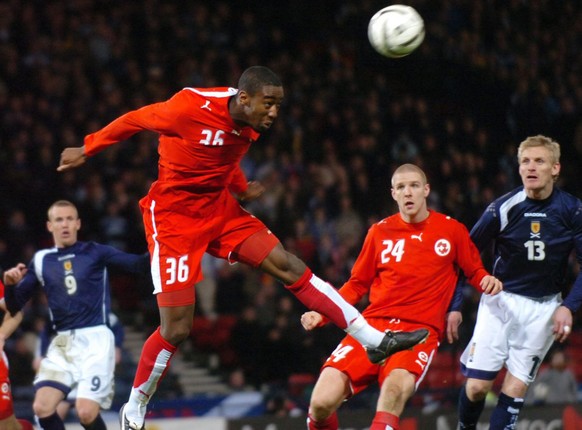 Switzerland&#039;s Johan Djourou, left, performs a header as Swiss Philippe Senderos and Scotland&#039;s Gary Teale, right, look on during their friendly soccer match in the Hampden Park stadium in Gl ...