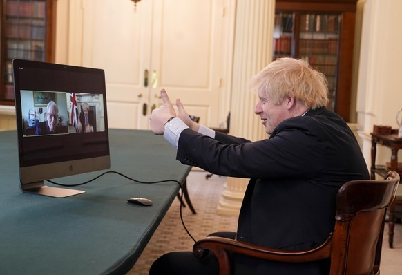 epa08410308 A handout photo made available by n 10 Downing street shows Britain&#039;s Prime Minister Boris Johnson video chating with WWII veteran Ernie Horsfall, 102, from the cabinet room in n10 Do ...