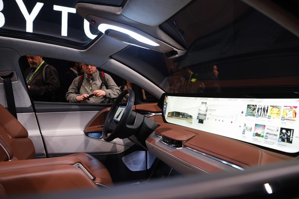 People photograph a car before a Byton news conference at CES International, Sunday, Jan. 6, 2019, in Las Vegas. (AP Photo/John Locher)