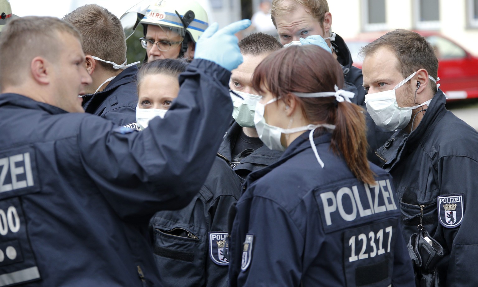 Polizisten erhalten Instruktionen vor dem Jobcenter, in dem zuvor eine Frau einen Schwächeanfall erlitt. Sie soll nach eigenen Angaben Kontakt zu Ebola-Patienten gehabt haben.&nbsp;