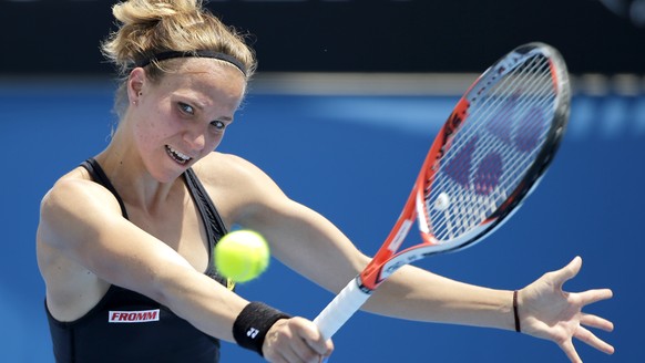 Viktorija Golubic of Switzerland makes a backhand return to Carla Suarez Navarro of Spain during their first round match at the Australian Open tennis championships in Melbourne, Australia, Monday, Ja ...