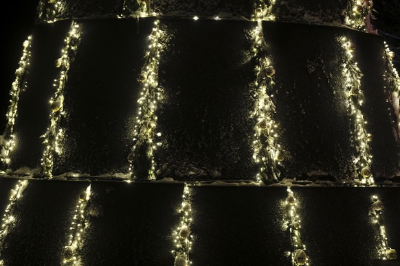 epa10357799 A part of a Christmas tree made of solar panels is erected in Trakai, Lithuania, 09 December 2022. The Christmas tree from solar panels generates energy and illuminates itself and, after t ...