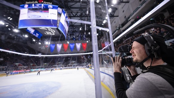Ein Kameramann filmt das Eishockeyspiel der National League zwischen den ZSC Lions und dem HC Ambri-Piotta mit einer UHD-Kamera fuer das Schweizer Fernsehen SRF, am Sonntag, 4. Februar 2024 in der Swi ...
