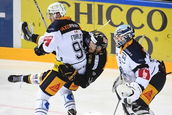 Zug&#039;s player Tobias Fohrler, LuganoÕs player Jani Lajunen and Zug&#039;s goalkeeper Tobias Stephan, from left, during the preliminary round game of National League Swiss Championship 2017/18 betw ...