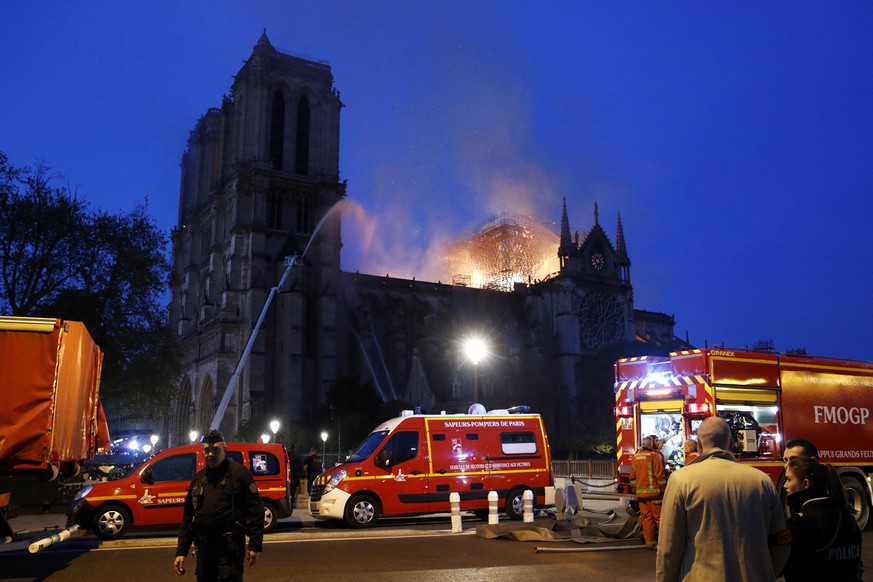 epa07508884 French firemen try to extinguish a fire as flames are burning the roof of the Notre-Dame Cathedral in Paris, France, 15 April 2019. A fire started in the late afternoon in one of the most  ...