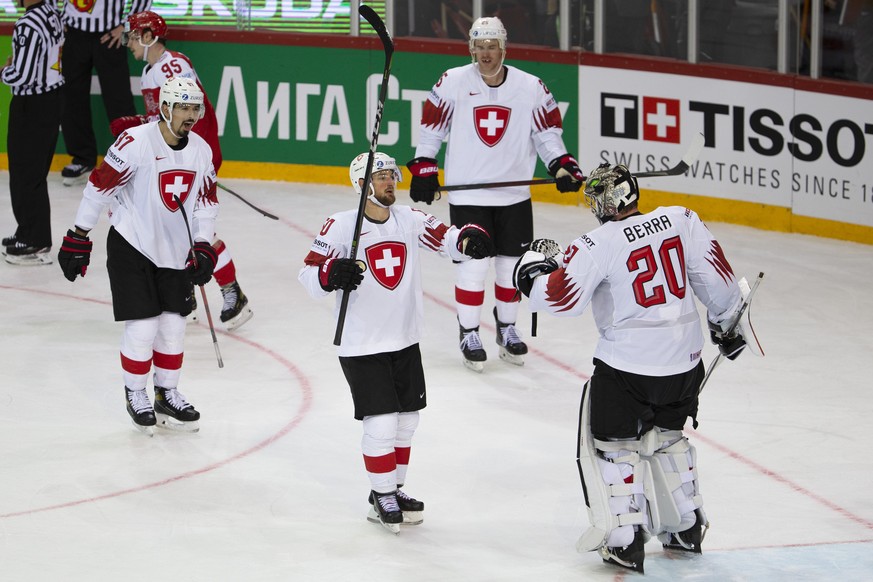 Switzerland&#039;s players defender Jonas Siegenthaler, left, forward Tristan Scherwey, defender Mirco Mueller, 2nd right, and goaltender Reto Berra, right, celebrate after wining against the Denmark, ...