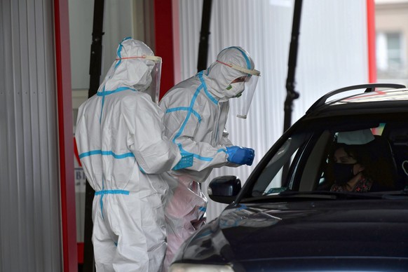 epa08769583 Polish medical staff work at a drive-thru COVID-19 testing lab in Szczecin, northwestern Poland, 24 October 2020. Countries around the world are taking increased measures to stem the wides ...