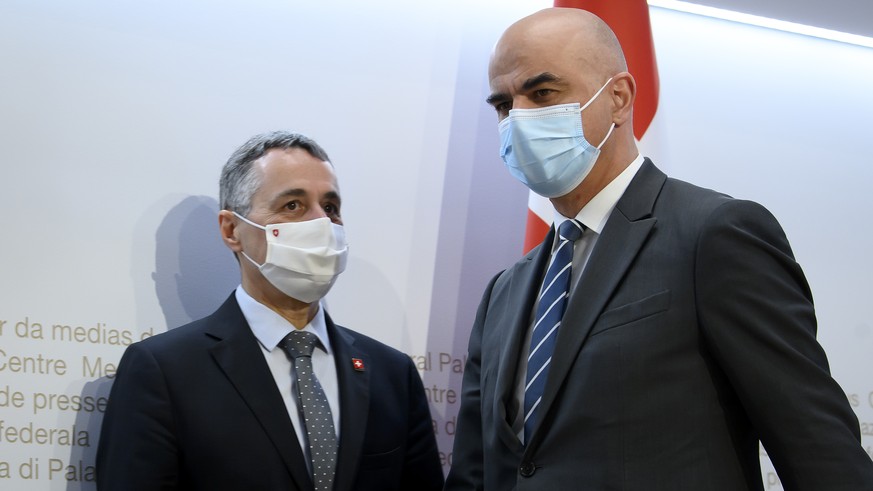 Bundespraesident Ignazio Cassis, links, und Bundesrat Alain Berset, rechts, kommen zur einer Medienkonferenz ueber die neusten Entscheide des Bundesrates zur Coronavirus-Pandemie, am Mittwoch, 16. Feb ...