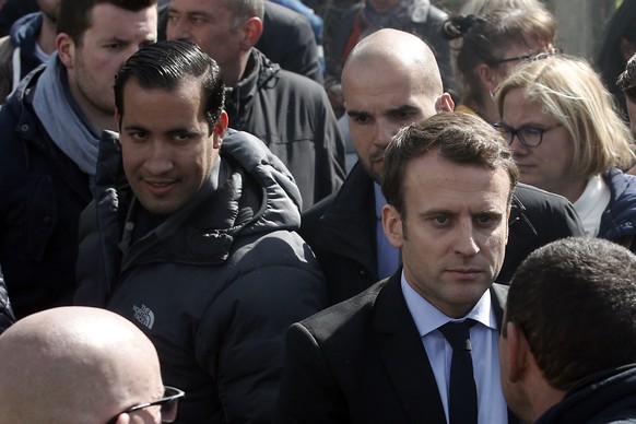 FILE - In this Wednesday April 26, 2017 file photo, Emmanuel Macron, right, is flanked by his bodyguard, Alexandre Benalla, left, outside the Whirlpool home appliance factory, in Amiens, northern Fran ...