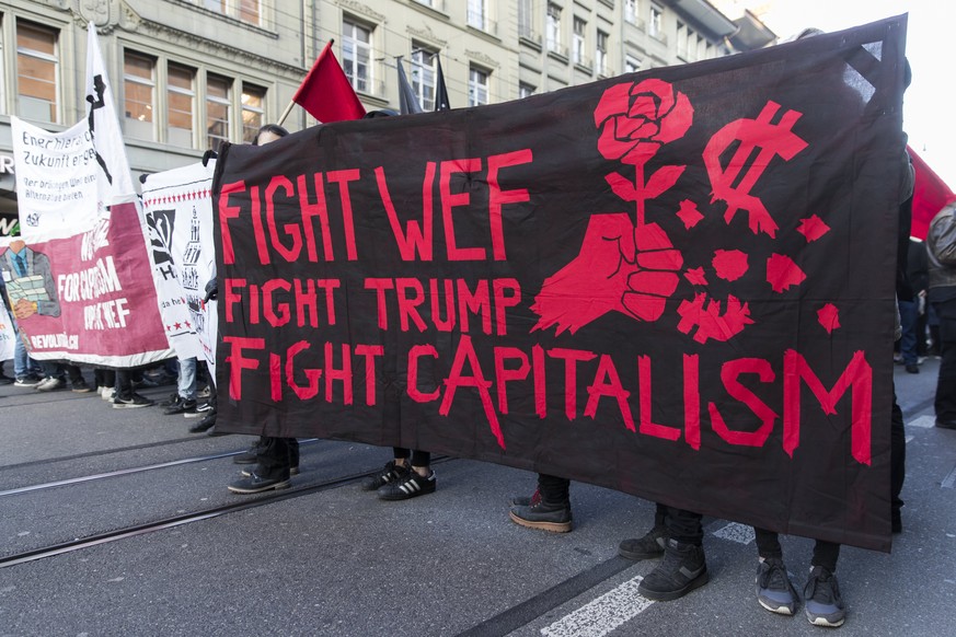 epa06435982 Protesters march with banners during a demonstration against the World Economic Forum (WEF) and US president Donald Trump, in Bern, Switzerland, 13 January 2018. The WEF will take place fr ...