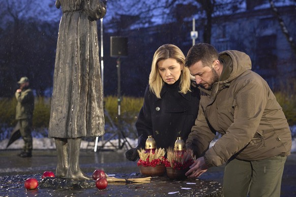 In this photo provided by the Ukrainian Presidential Press Office, Ukrainian President Volodymyr Zelenskyy and his wife Olena pay tribute at a monument to victims of the Holodomor, Great Famine, which ...