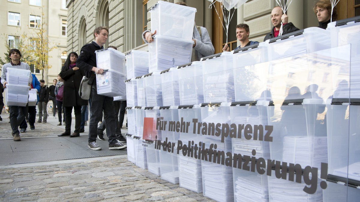 Personen laufen mit den Boxen, die Unterschriften enthalten, in Richtung Bundeshaus-West wahrend der Einreichung der Transparenz-Initiative, am Dienstag, 10. Oktober 2017 in Bern. Das ueberparteiliche ...