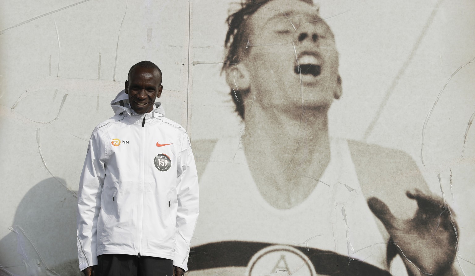 Marathon world record holder Kenya&#039;s Eliud Kipchoge poses for photographers next to an image of British athlete Roger Bannister, who in 1954 ran to become the first person ever to break the four  ...