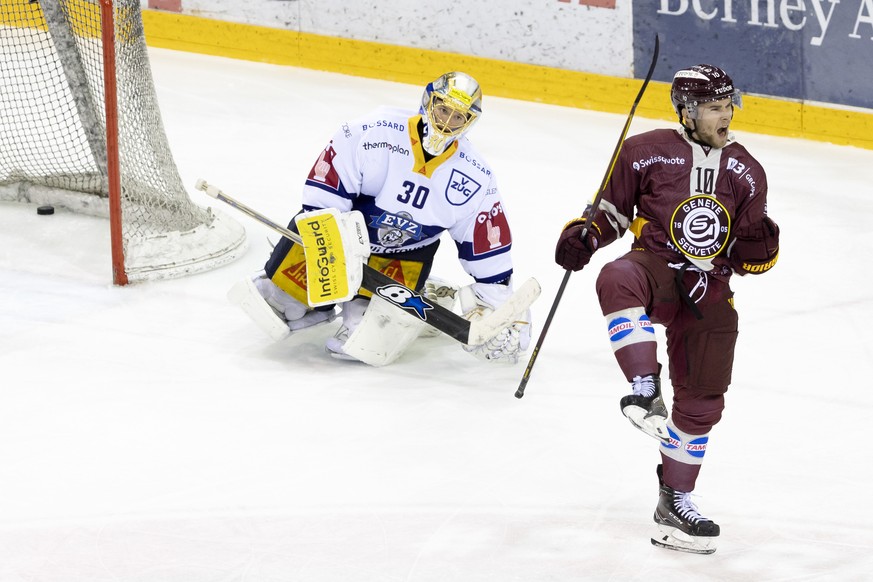 Geneve-Servette&#039;s forward Deniss Smirnovs celebrates his goal past Zug&#039;s goaltender Leonardo Genoni, left, after scoring the 4:0, during a National League regular season game of the Swiss Ch ...