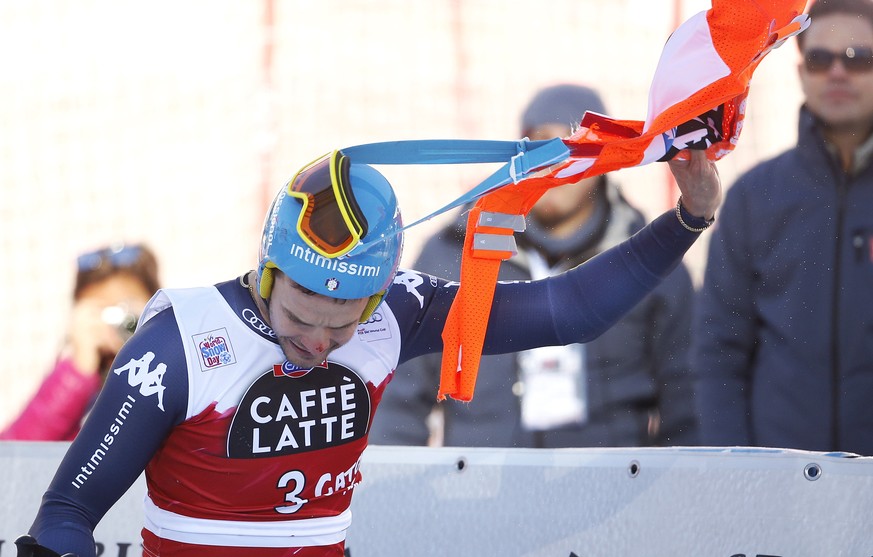 Das Bild des Tages: Christof Innerhofer streift sich im Ziel die Torflagge ab.