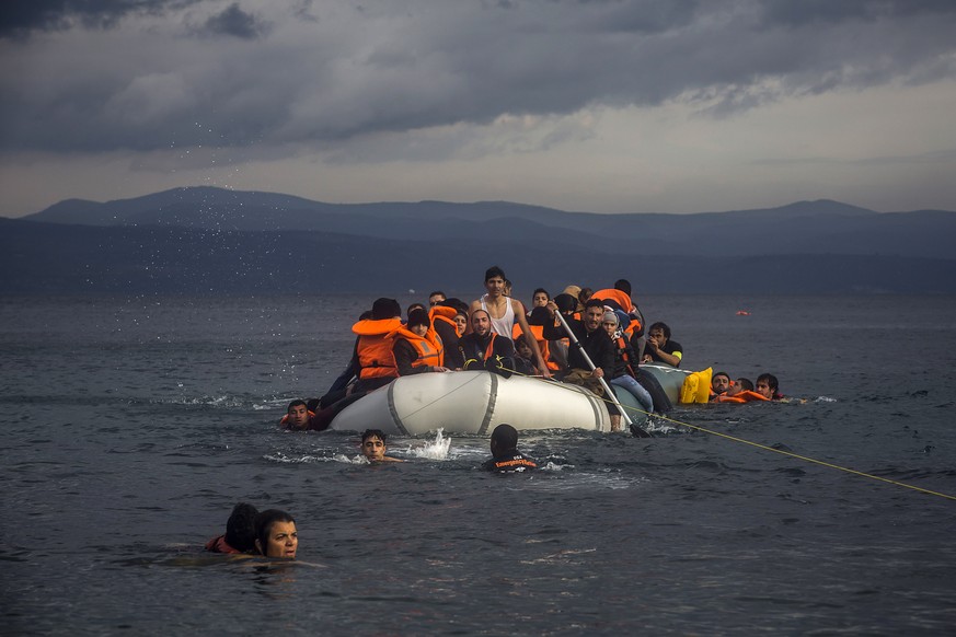 Volunteers help refugees to approach the coast after engine problems on their dinghy in the northeastern Greek island of Lesbos Wednesday, Nov. 25, 2015. About 5,000 migrants reaching Europe each day  ...