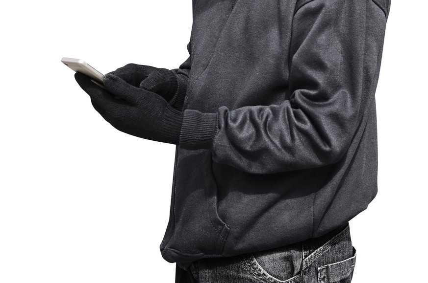Hacker mit Smartphone und Hoodie (Symbolbild)