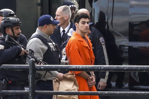epa11786490 Luigi Mangione (C) is escorted by police officers as he arrives in New York City, after being extradited from Pennsylvania, to face charges that he murdered UnitedHealthcare CEO Brian Thom ...