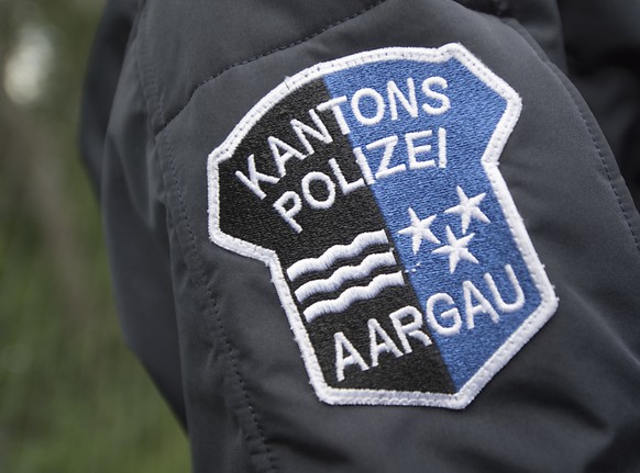 Das Logo der Kantonspolizei Aargau auf der Uniform eines Polizisten: Laut Polizei war ein 39-Jähriger betrunken in seinem neuen Tesla unterwegs, auf dem Schoss sein Kind. (Symbolbild)