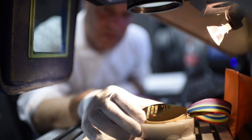 Nachdem die edlen Stücke poliert wurden, kommen sie unter den Laser. Nach wenigen Sekunden stehen auf der Medaille der Name, die Disziplin und die Schlusszeit des Athleten drauf.