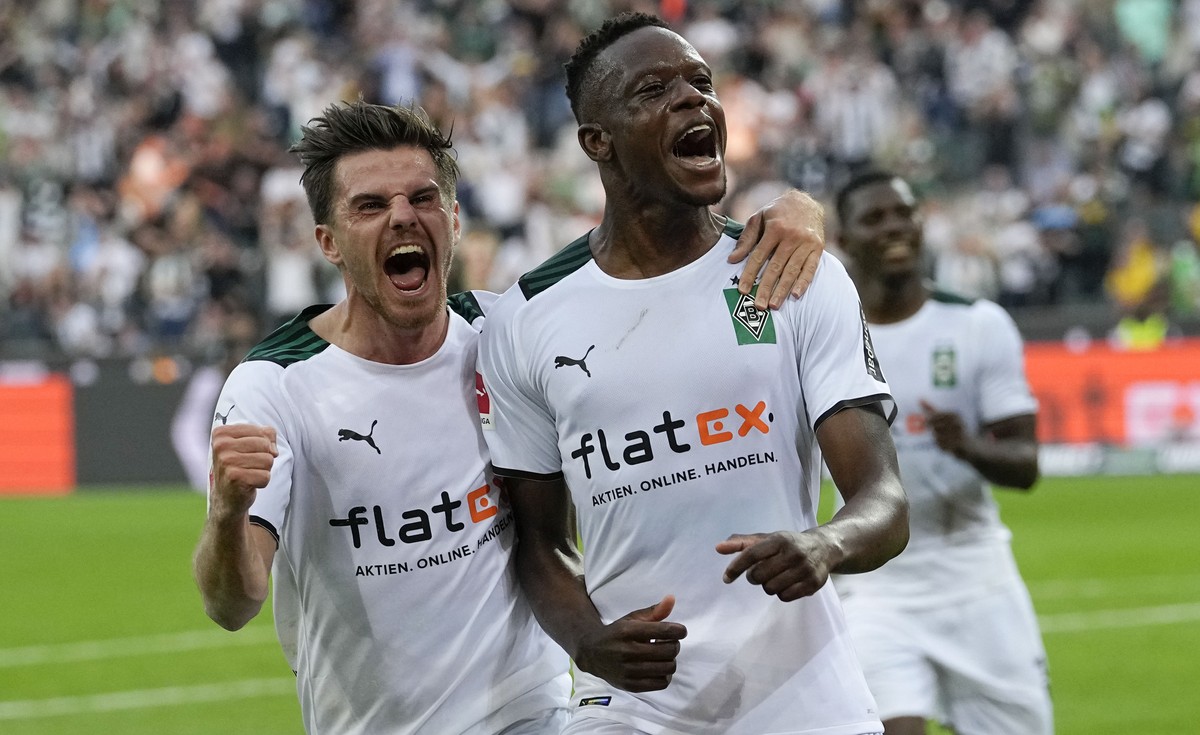 Moenchengladbach's scorer Denis Zakaria, right, celebrates with Moenchengladbach's Jonas Hofmann, left, after he scored the opening goal during the German Bundesliga soccer match between Bor ...