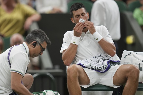 &lt;p&gt;Novak Djokovic schluckt Medikamente, während er behandelt wird.&lt;/p&gt;