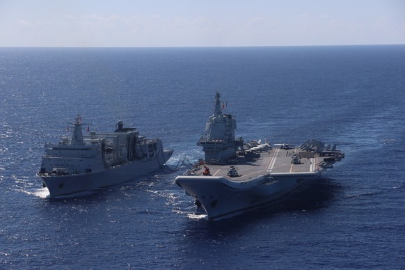 epa12206543 An undated photo released by Xinhua on 30 June 2025 shows the formation with aircraft carrier Shandong (R) conducting replenishment-at-sea at an undisclosed location at sea. China's n ...