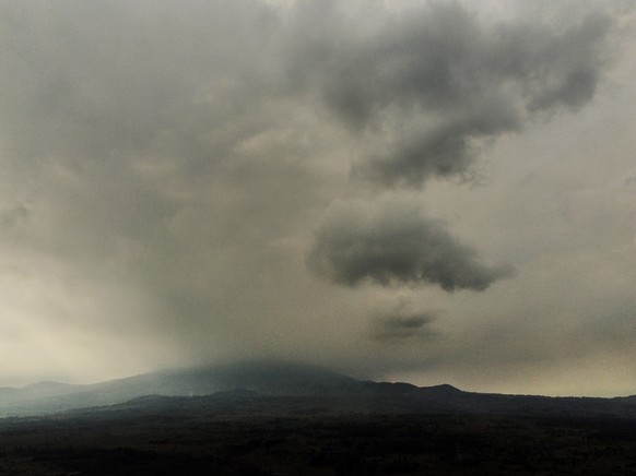 epa09227815 Mount Nyiragongo is seen shrouded in smoke and dust in the aftermath of a volcanic eruption in North Kivu, Democratic Republic of Congo, 25 May 2021. One of the planets most active volcano ...