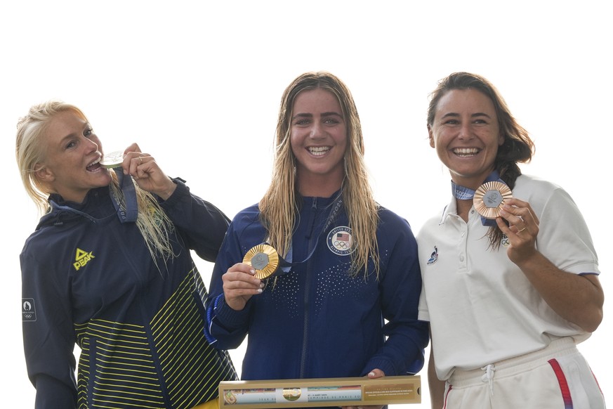 From left, silver medalist Tatiana Weston-Webb, of Brazil, gold medalist Caroline Marks, of the United States, and bronze medalist Johanne Defay, of France, celebrate with their medals on the podium a ...