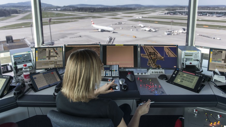 Eine Mitarbeiterin von Skyguide kontrolliert die Monitore und hat Blick auf das Flugfeld des Flughafens Zürich.